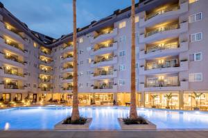圣苏珊娜AQUA Hotel Montagut Suites 4*Sup的前面有两棵棕榈树的酒店游泳池