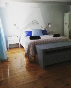 卡索拉Alojamiento San Juan Bautista的卧室配有白色的床,铺有木地板