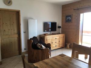维拉尔叙尔多龙La Perle Des Alpes C2的客厅配有电视、椅子和桌子