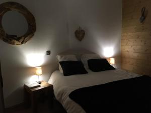 维拉尔叙尔多龙La Perle Des Alpes C2的一间卧室配有一张带两盏灯和镜子的床