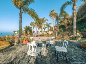 丰沙尔海洋花园酒店的棕榈树庭院内的桌椅