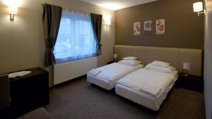 布达厄尔什Varga-ház panzió的酒店客房设有两张床和窗户。