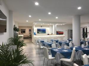 阿祖罗港Hotel Barbarossa的宴会厅配有蓝色的桌子和白色的椅子