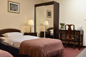 维隆兹隆纳维兰达酒店的一间卧室配有一张床、一张桌子和一把椅子