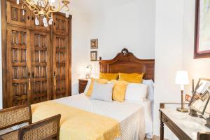 埃尔博斯克Mafloras Suites El Bosque的一间卧室配有一张带木制床头板的床
