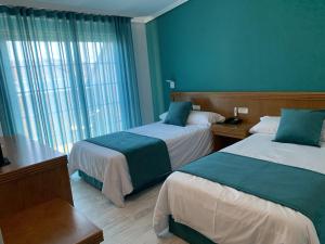 托米尼奥努埃瓦科利纳酒店的酒店客房设有两张床和窗户。