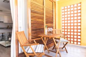 法纳贝海滩HomeForGuest BEACH APT WITH SEA VIEW & POOL, 50 STEPS TO THE SEA的一间带木桌和两把椅子的用餐室