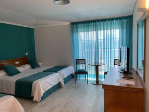托米尼奥努埃瓦科利纳酒店的一间卧室配有一张床、一张书桌和一台电视