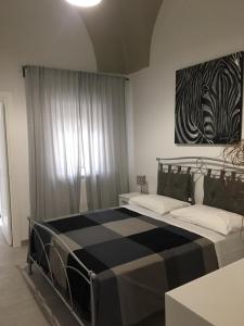 卡洛维诺Guest House Nonna Lena的卧室配有一张黑色和白色的大床。