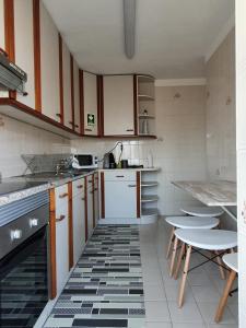 加亚新城Ninho Jardim do Morro的厨房配有白色橱柜和黑白瓷砖地板。