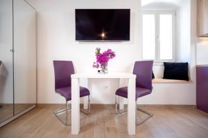 赫瓦尔Velada Center的白色桌子,带紫色椅子和花瓶