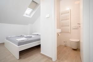 赫瓦尔Velada Center的白色的浴室设有床和卫生间。