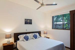 里瓦斯Eco Casita Phase III #2: Casa de Olas的一间卧室配有一张带吊扇的床