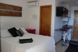 巴西利亚Life Resort的卧室配有一张白色的床,上面装有黑色钱包