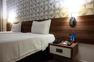 库亚巴德卢卡酒店的酒店客房设有两张床和一张桌子上的电话