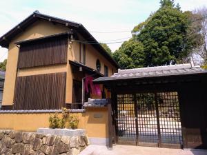宫岛Miyajima Fujinoya Female Only的一座带门和石墙的房子
