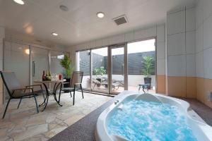 Ginan岐阜矿山情趣酒店（仅限成人）的带浴缸的客房内配有桌椅