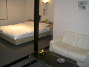 二世古新雪谷有乐酒店的酒店客房配有床、沙发和桌子。
