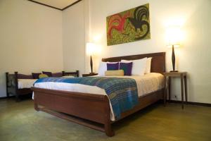 琅勃拉邦飞天酒店的一间卧室配有一张大床和两盏灯