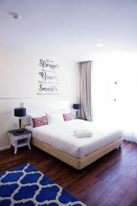 瓜拉丁加奴TY Hotel的卧室配有一张白色大床和蓝色地毯。