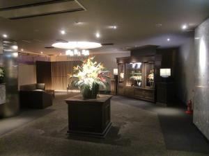 韮崎市Hotel GOLF Nirasaki (Adult Only)的大堂,桌子上放着花瓶