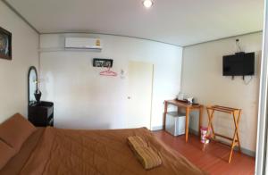 拉差汶里阿若斯瑞泰拉旅馆的卧室配有一张床,墙上配有电视