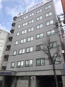 札幌HOTEL LiVEMAX Sapporo Ekimae的一座大型灰色建筑,上面有标志