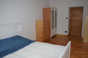 格丁尼亚Apartament 2-pokojowy Gdynia Świętojańska的卧室配有白色的床和木制梳妆台。
