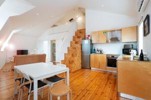 维塞乌Apartamentos Premium Familiares - Loft Guesthouse BeMyGuest Viseu的厨房以及带白色桌椅的用餐室。