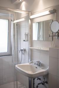 格绍高斯豪斯米德宾馆的白色的浴室设有水槽和淋浴。
