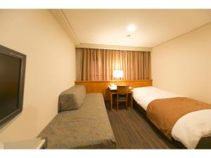 高松Hyper-inn Takamatsu Ekimae的酒店客房设有两张床和电视。