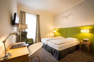 策尔廷根-拉蒂希德国庄园酒店的配有一张床和一张书桌的酒店客房