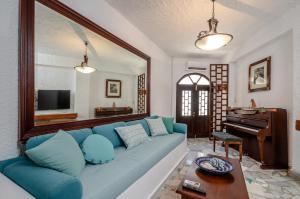 纳克索乔拉Naxos Center Houses的客厅配有蓝色的沙发和钢琴