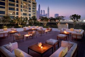 迪拜阿联酋山庄葳达酒店的屋顶庭院设有沙发和桌子,享有城市天际线