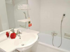 帕多瓦多纳泰罗酒店的白色的浴室设有水槽和淋浴。