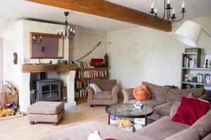 Saint-Fort-sur-GirondeLe Charhido的客厅配有沙发、椅子和壁炉