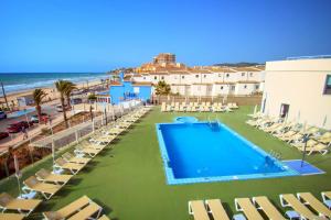 奥罗佩萨德尔马Hotel Servigroup Koral Beach的一个带躺椅的游泳池和海滩