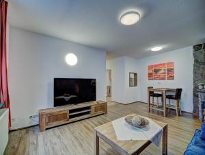 蒙绍Gästehaus Eschbach的客厅配有平面电视和桌子。