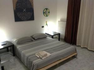 塔兰托Appartahotelpuglia Gruppo Albergo Lamanna的一间卧室配有一张带两张桌子和两条毛巾的床。