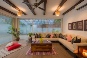 罗纳瓦拉EL Lodge by StayVista - Pool, lawn, and a charming gazebo for your perfect getaway的客厅配有沙发和桌子