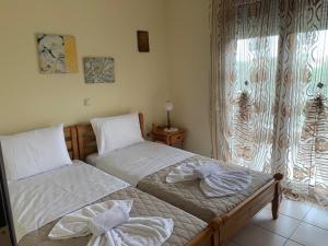 萨索斯Rania House的卧室设有两张单人床和窗户。