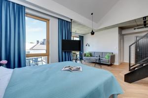 索波特Pogodna Apartments的一间带蓝色床的卧室和一间客厅