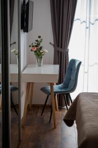瓦比尼科SOBE "GALEB"的一间设有桌子和两把椅子的房间和一个花瓶