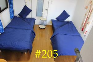 大阪マンションロアジス 大阪市東淀川区相川的配有蓝色枕头的客房内的两张床