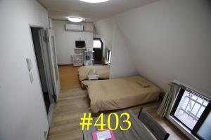 大阪マンションロアジス 大阪市東淀川区相川的小房间设有一张床和一张桌子