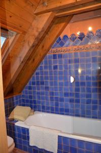 博索斯特Laurit的蓝色瓷砖浴室设有白色浴缸