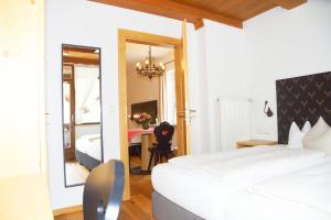 加尔米施-帕滕基兴弗劳多福酒店旅馆的一间卧室配有一张床、一张桌子和一面镜子