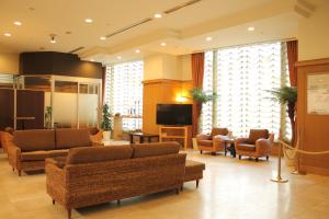 鹿儿岛HOTEL LiVEMAX BUDGET Kagoshima的大堂配有沙发、椅子和电视。
