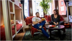 爱丁堡皇家大道背包客客栈的男人和女人在带双层床的房间看书