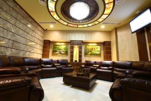埃里温New Nairi Hotel的一间设有皮革家具和圆形天花板的等候室